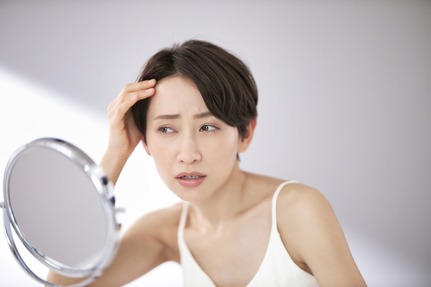 鏡を見る女性の画像
