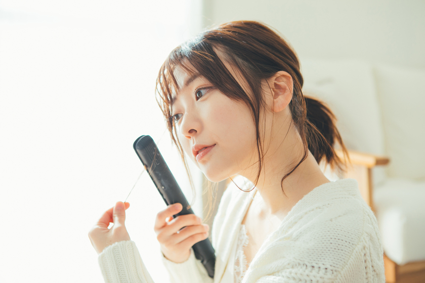 ヘアアイロンで髪を巻いている画像