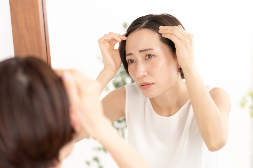 髪を気にしている女性の画像