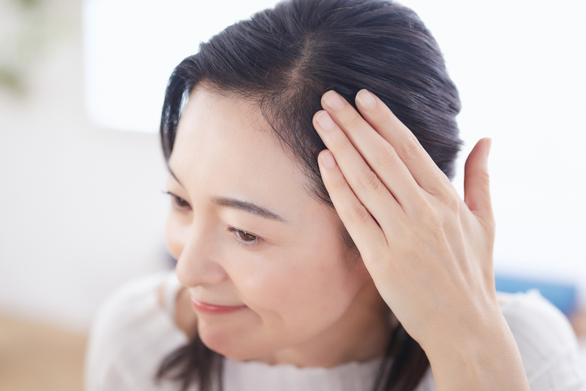 女性が髪を触る画像