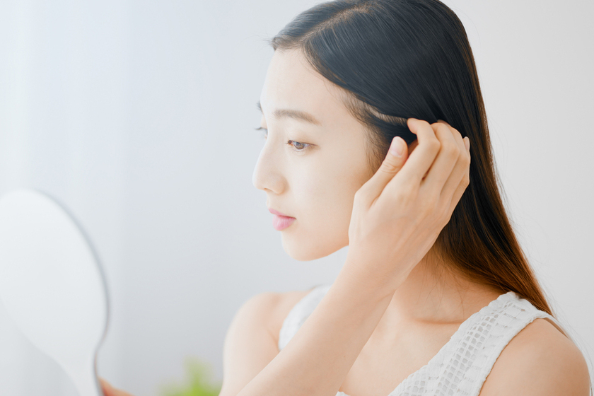鏡を見る女性の画像