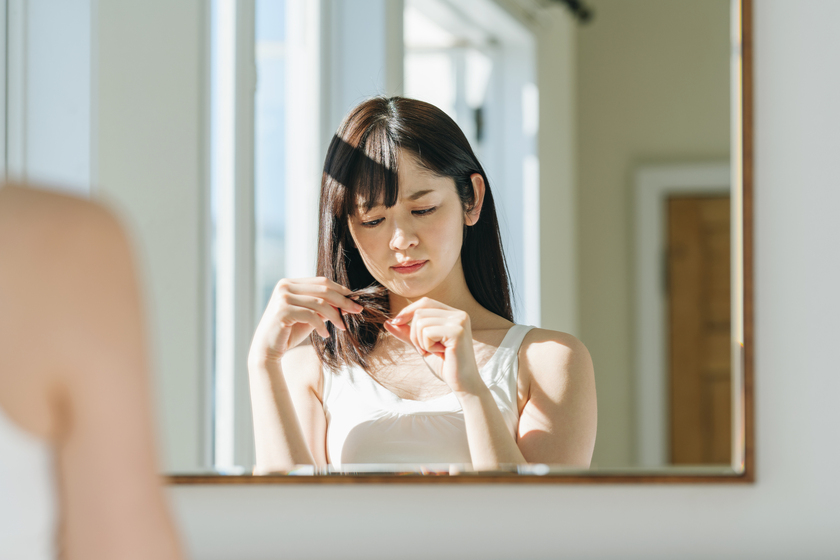 髪を触る女性の画像